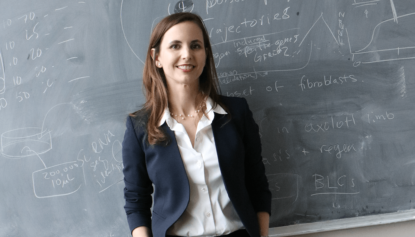 Portrait of Jessica Whited, standing in front of her chalkboard