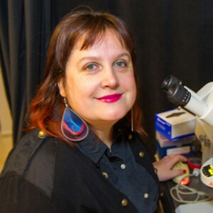 Photo of Maria Barna at a microscope
