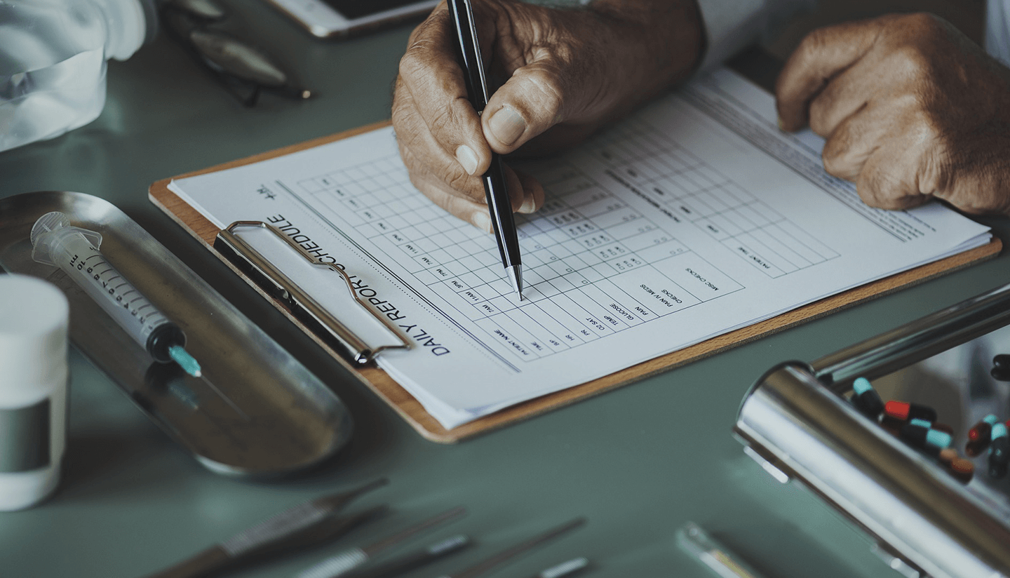 Stock photo of someone writing on a health record